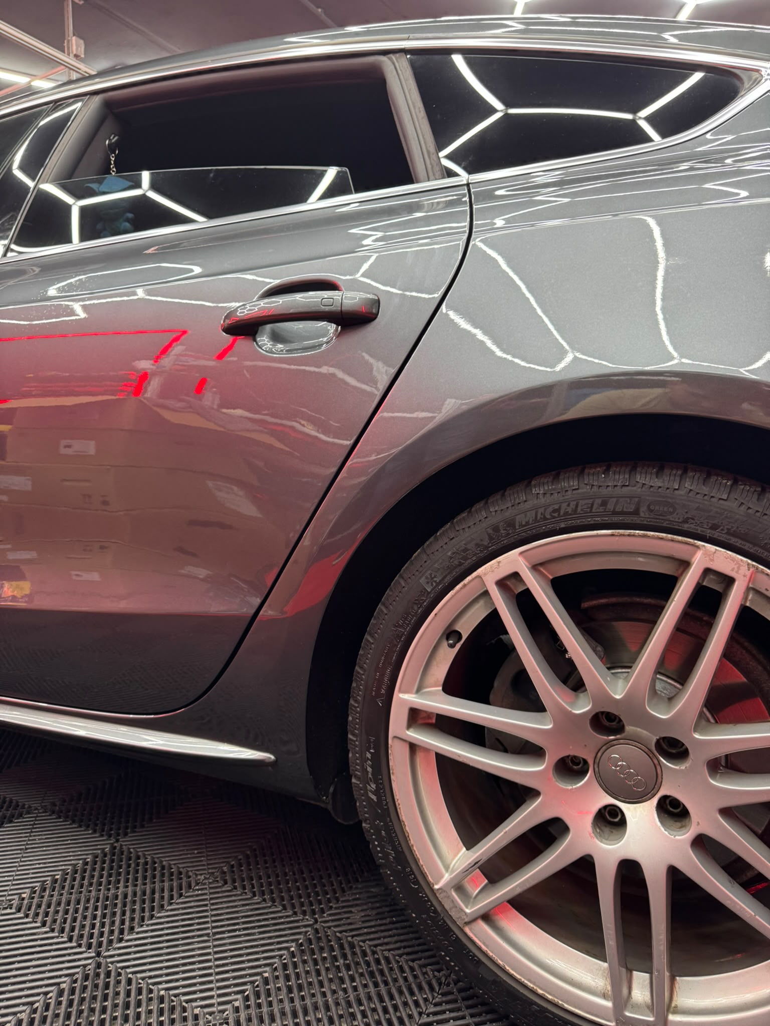 Derselbe Audi nach der Reparatur — makellos und poliert in der Halle
